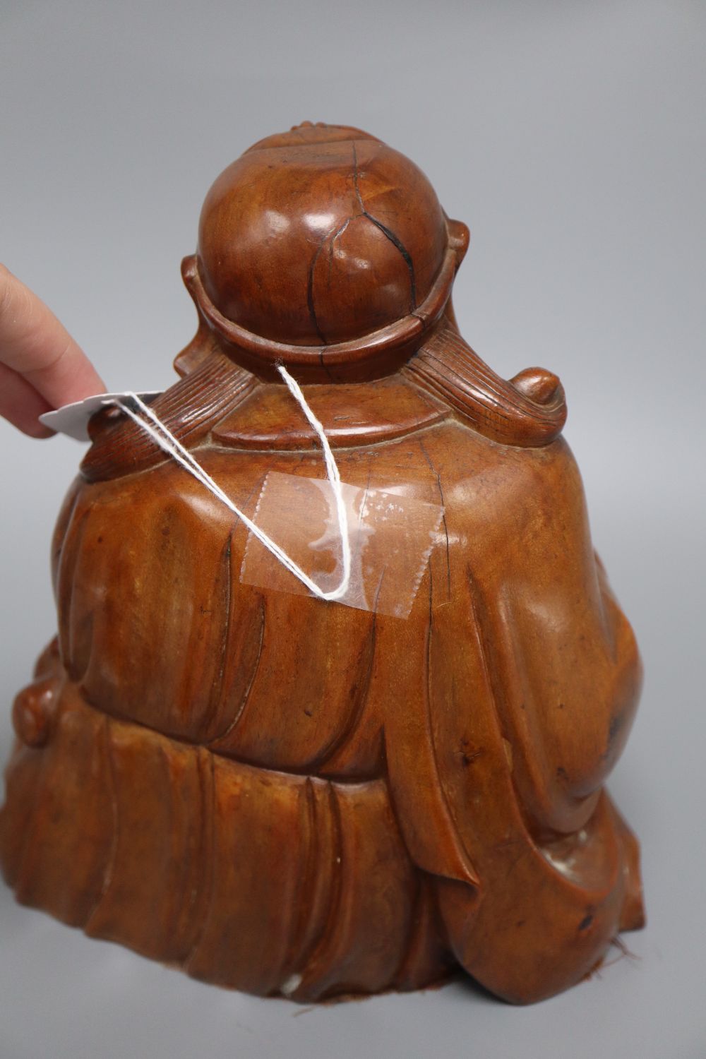 A Japanese rootwood carving of a seated elder, inset eyes and teeth and a pair of Chinese soapstone shishi, each crouched on a rectangu